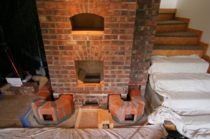 Shows the flue liners that form the channels that heat the bench before they are covered by the facing. The left side wraps around and crosses at the back underneath the firebox to reunite with the right side at the base of the chimney. flue liner detail
